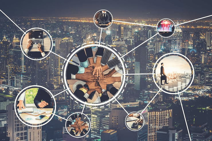 A cityscape at night with a network of circular insets connected by lines, symbolizing collaboration and business networking. The central circle shows multiple hands stacked together in unity, while surrounding circles depict various business activities such as working on laptops, handshakes, meetings, and professional attire.