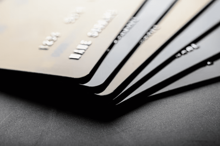 Close-up view of stacked black credit cards on a dark surface, representing premium credit card options and financial products.