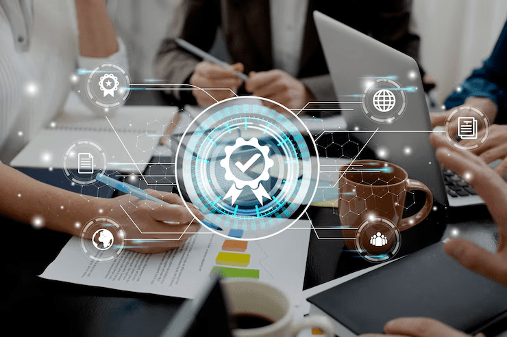 Business professionals working on laptops and documents with a digital overlay of a quality assurance icon, symbolizing certification, compliance, and secure digital processes.